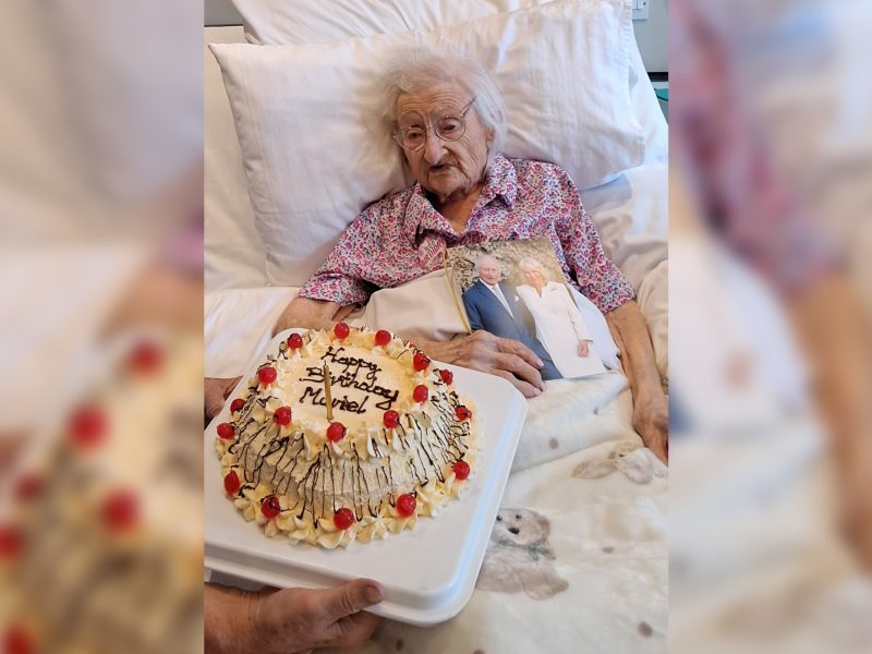 Muriel at Westbury Care Home with her card from the King and Queen and her cake